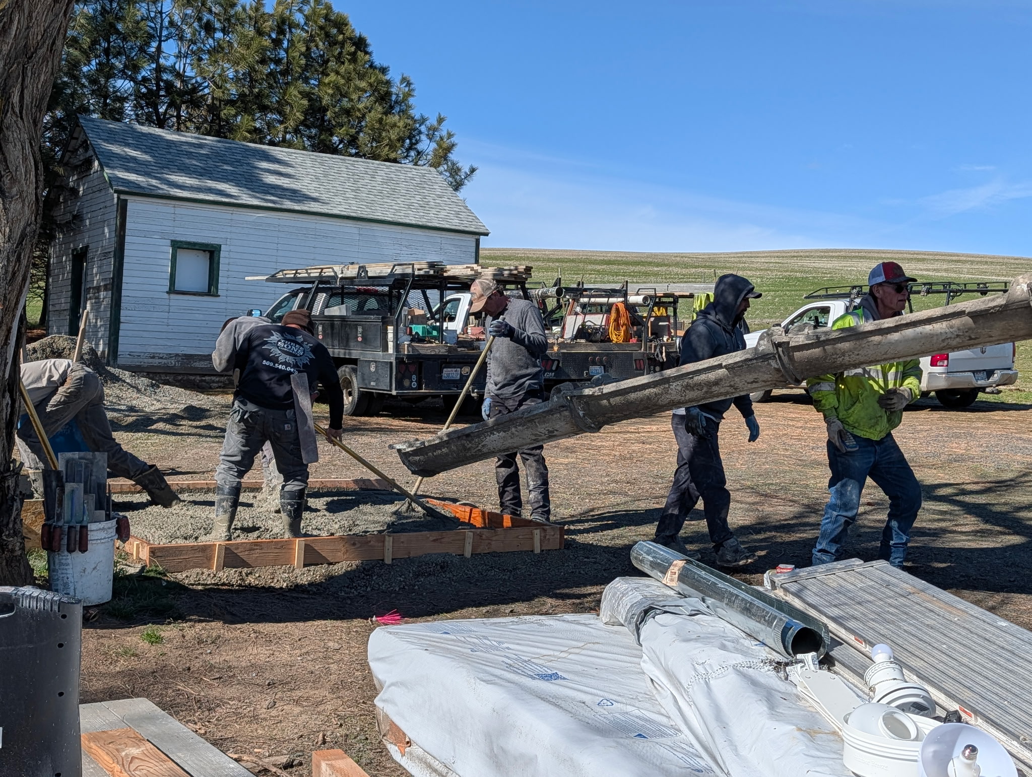 Volunteers pouring and finishing a new accessible concrete pathway